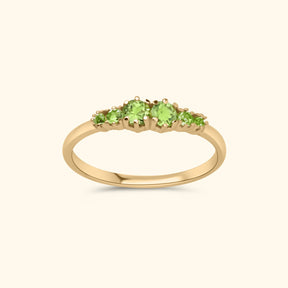 Goudkleurige ring met zes heldergroene peridot stenen in oplopende grootte, gezet in gold plated messing.
